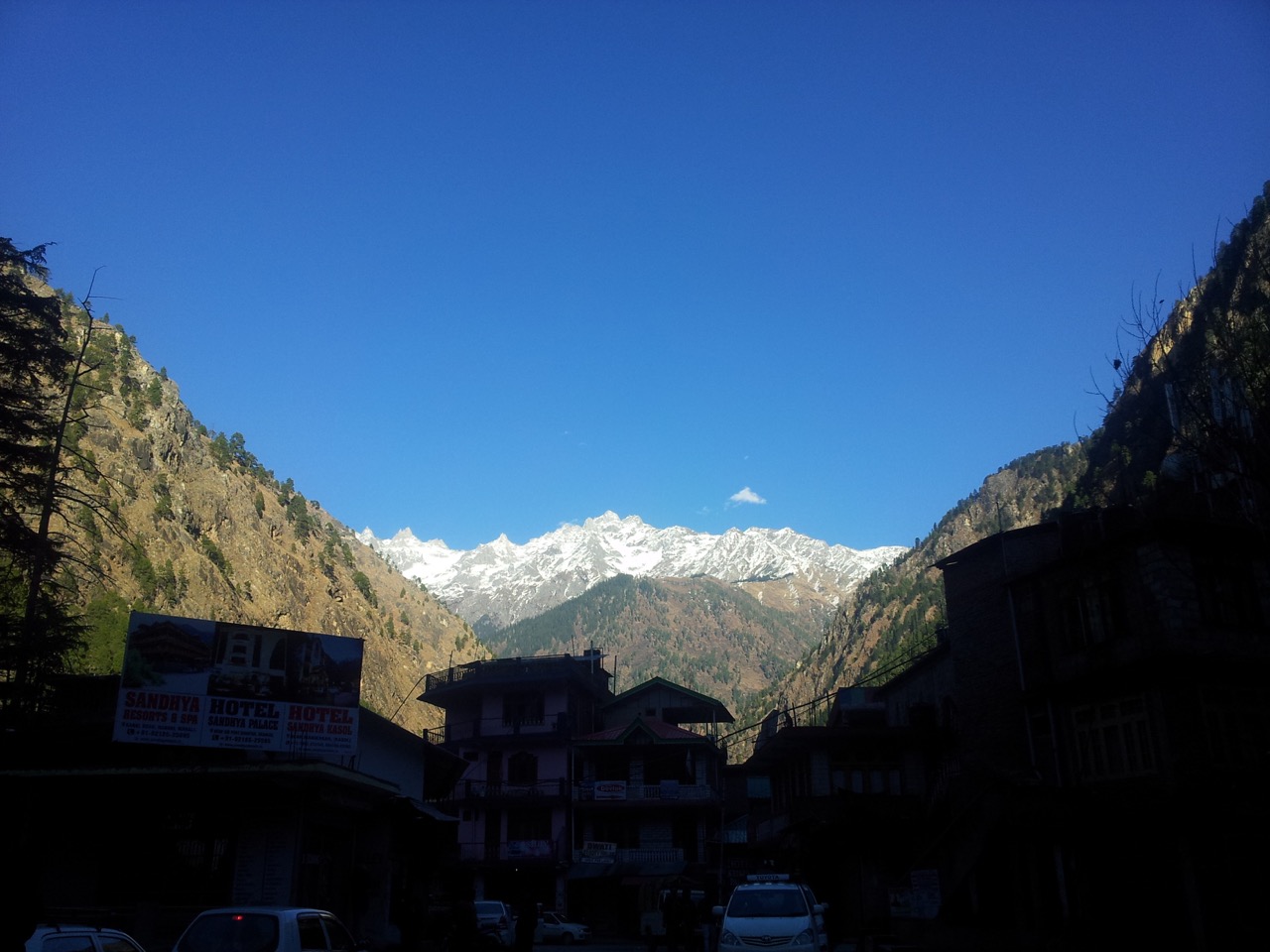 The snow clad Himalayas from the bridge that connects Old and New Kasol.