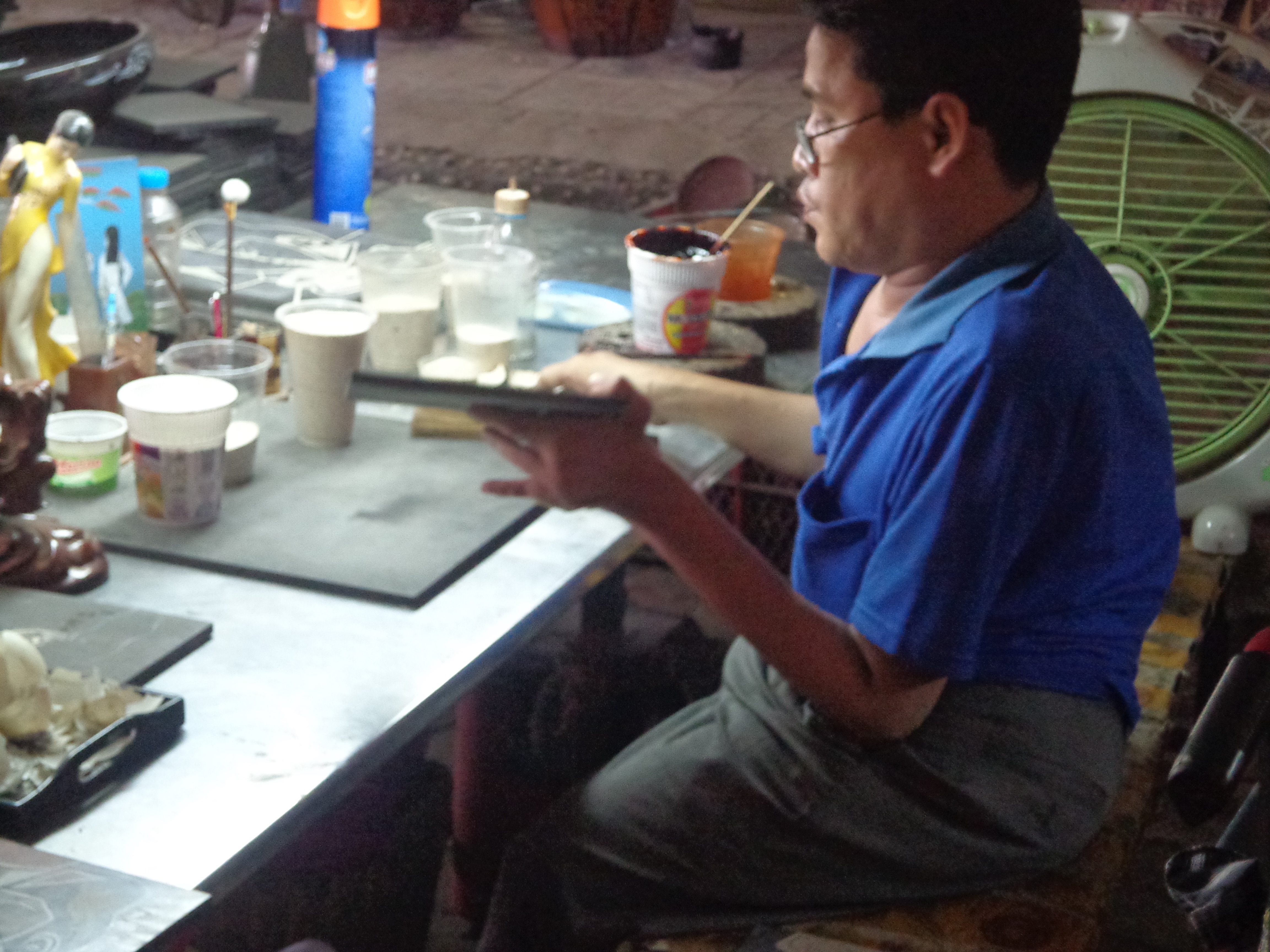 An Agent Orange victim working with eggshells for an art installation.
