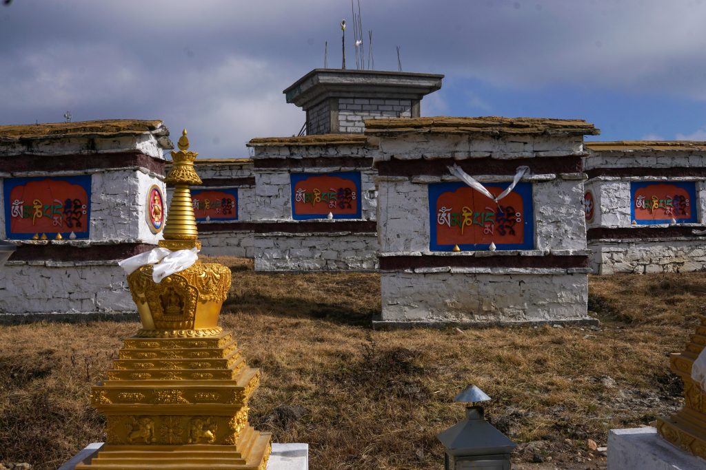 Close up of a few manis with the incomplete central stupa in the background.