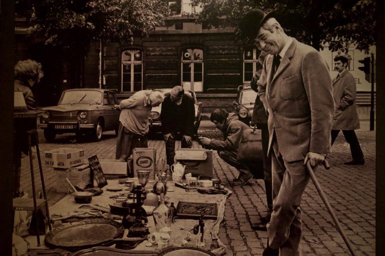 Hergé posing in front of a market in Brussels.