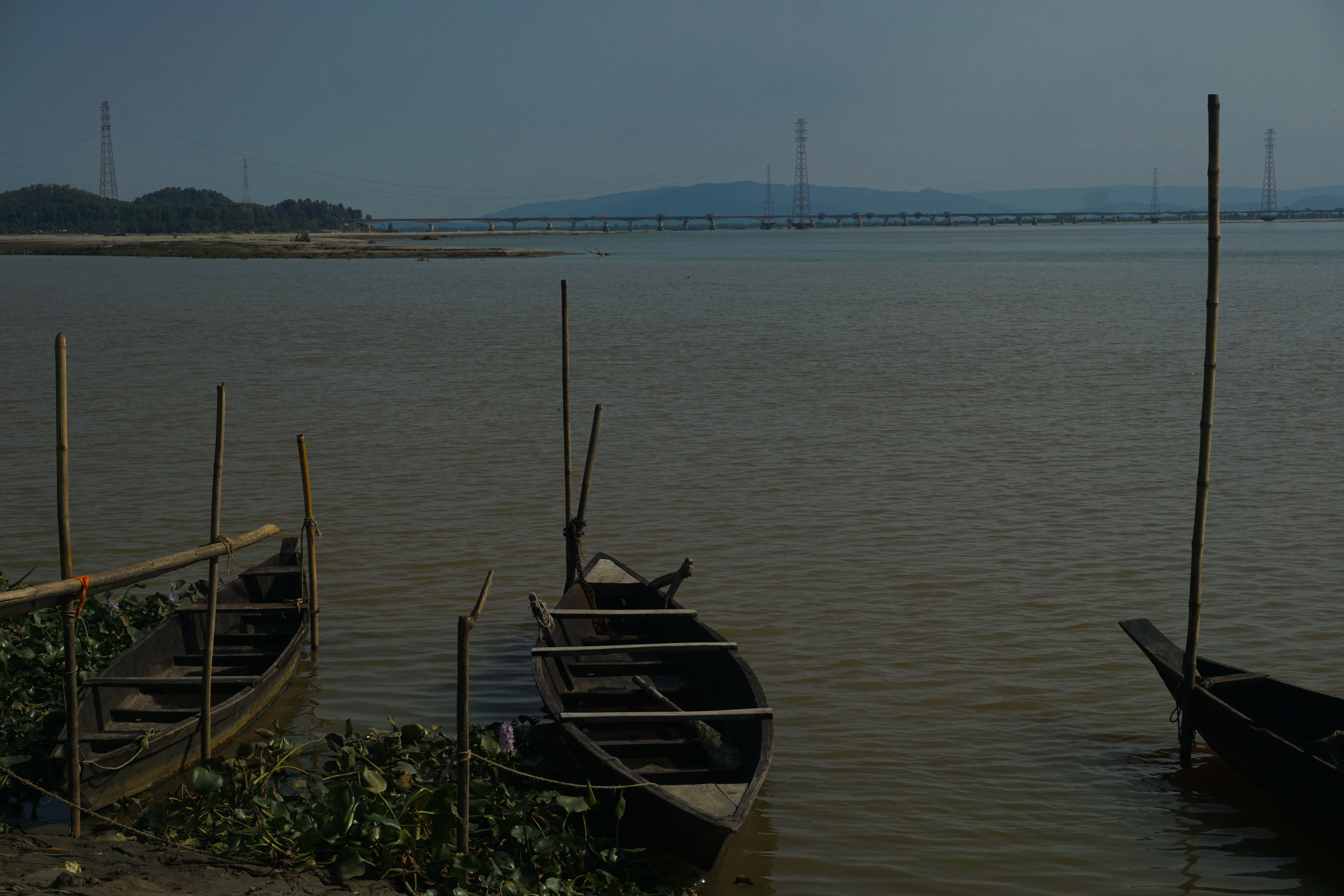 Small fishing boats anchored at the shore of the river, right near the entrance of Bamuni Hills.