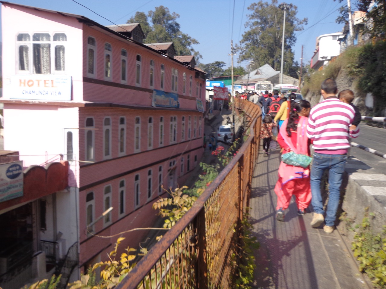 The road to the bus stop has a hanging road for pedestrians.