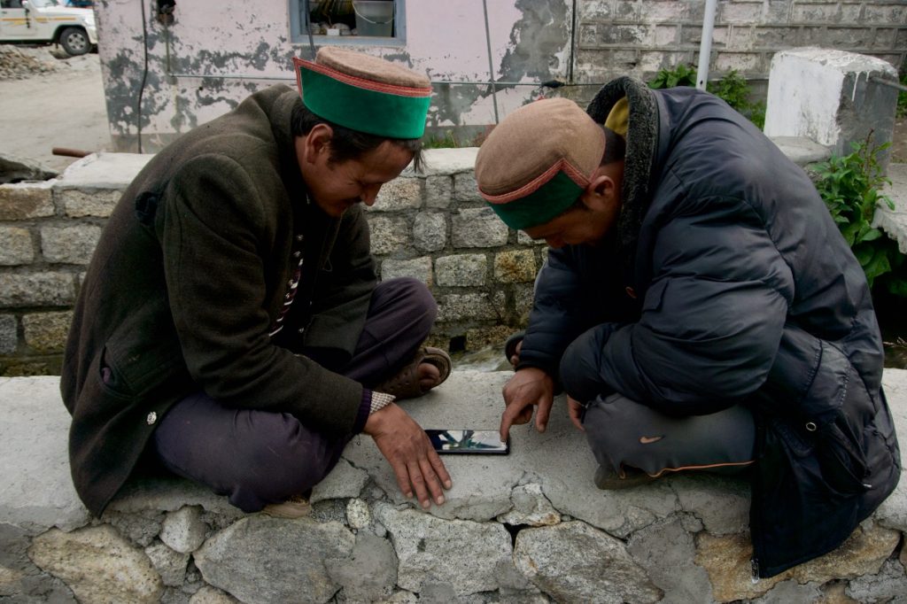 People have moved on with the times. Two guys playing ludo with a smartphone instead of using physical board, dice and pieces.
