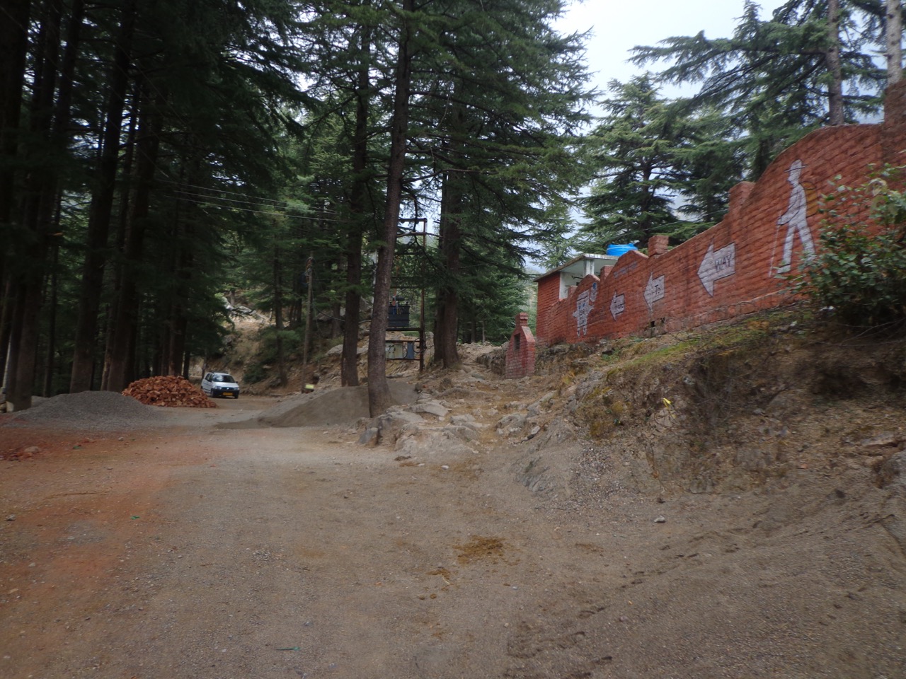 The walking trail to Triund is between the trees and the wall that belongs to Govt. Primary School of Dharamkot. I took the proper road instead.