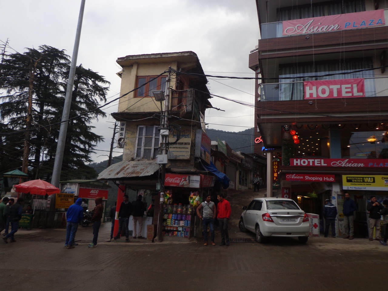 The small road sandwiched between the two buildings is the shortest route to Dharamkot.