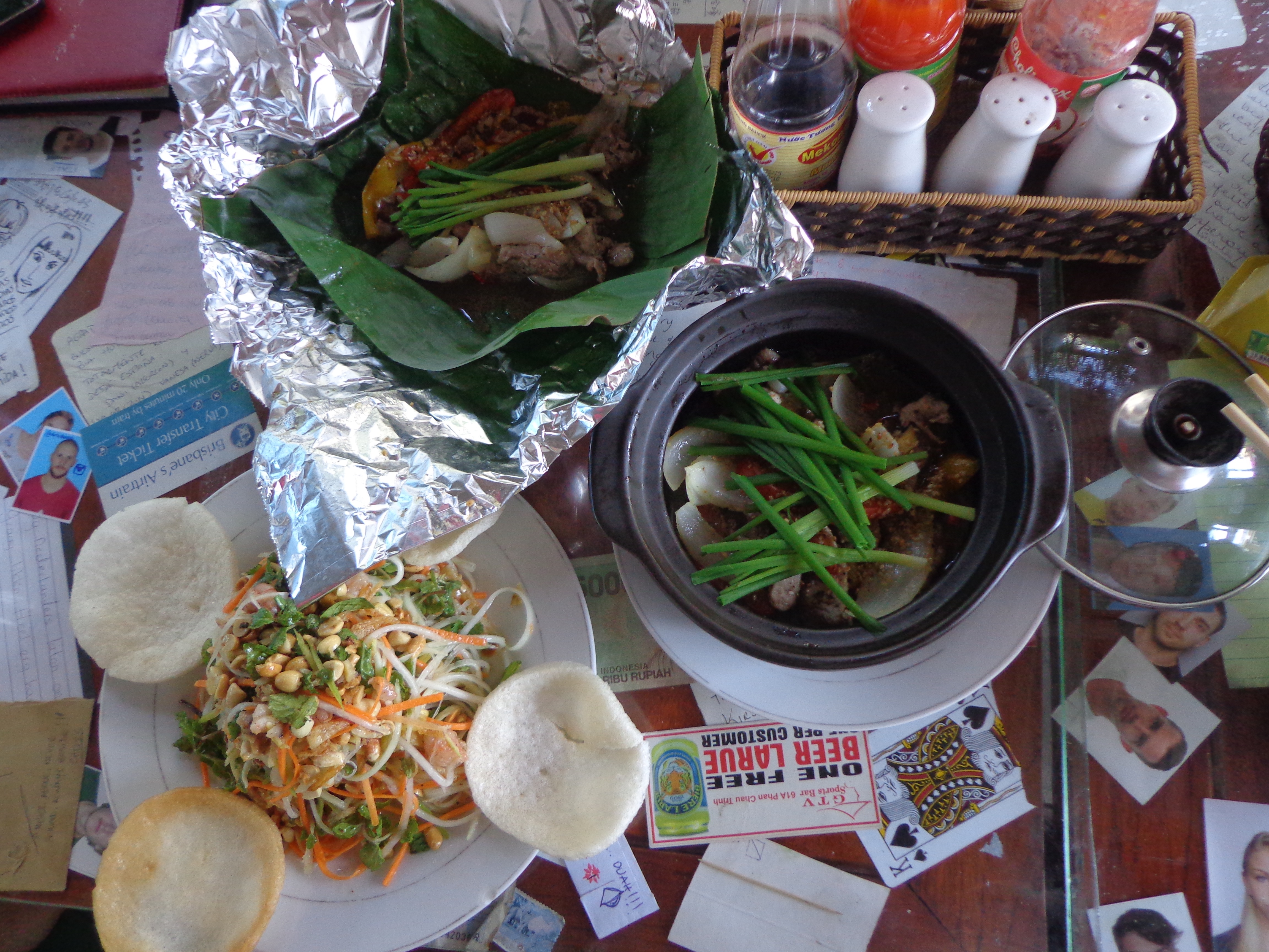 Clockwise from bottom left - Papaya Salad with shrimp, Roasted beef in banana leaf and Pork in clay pot.