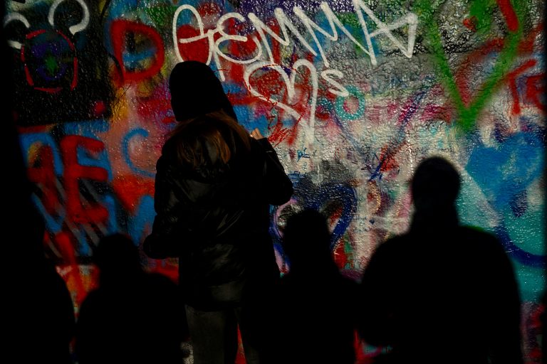A school kid drawing a heart. The wall is free for anyone to draw.