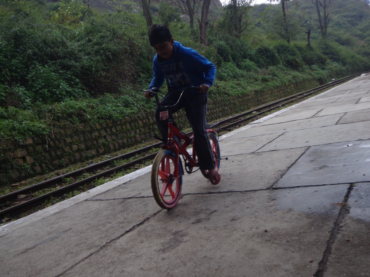 A kid was practicing his cycling skills on the small platform.