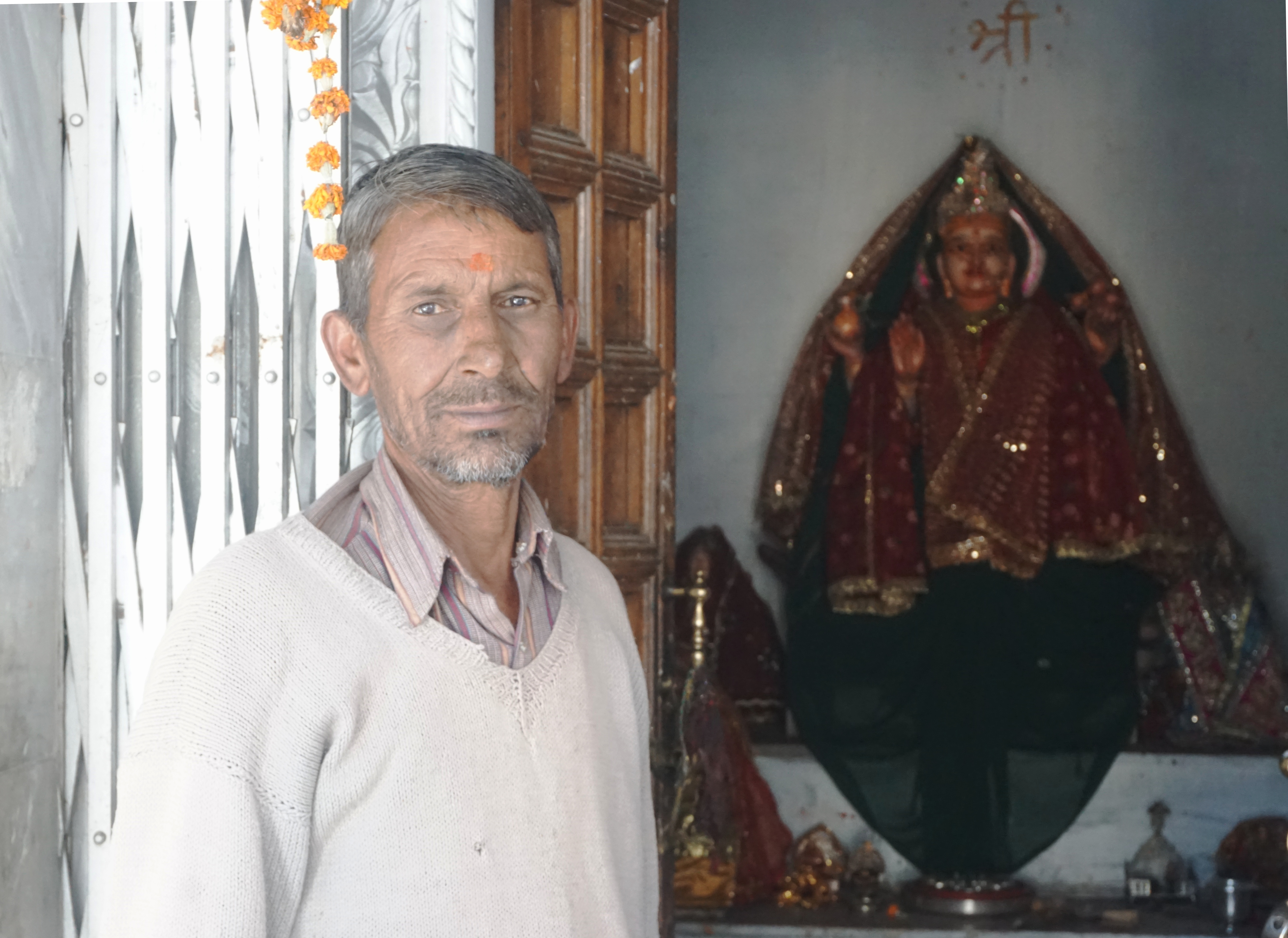 Mr. Govind, the purohit, posing in front of Ganga idol.