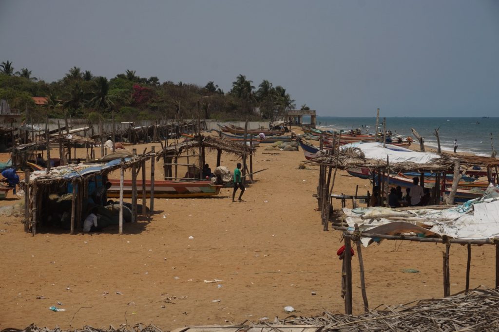 Bamboo skeletons of empty shops spread across Auroville beach.