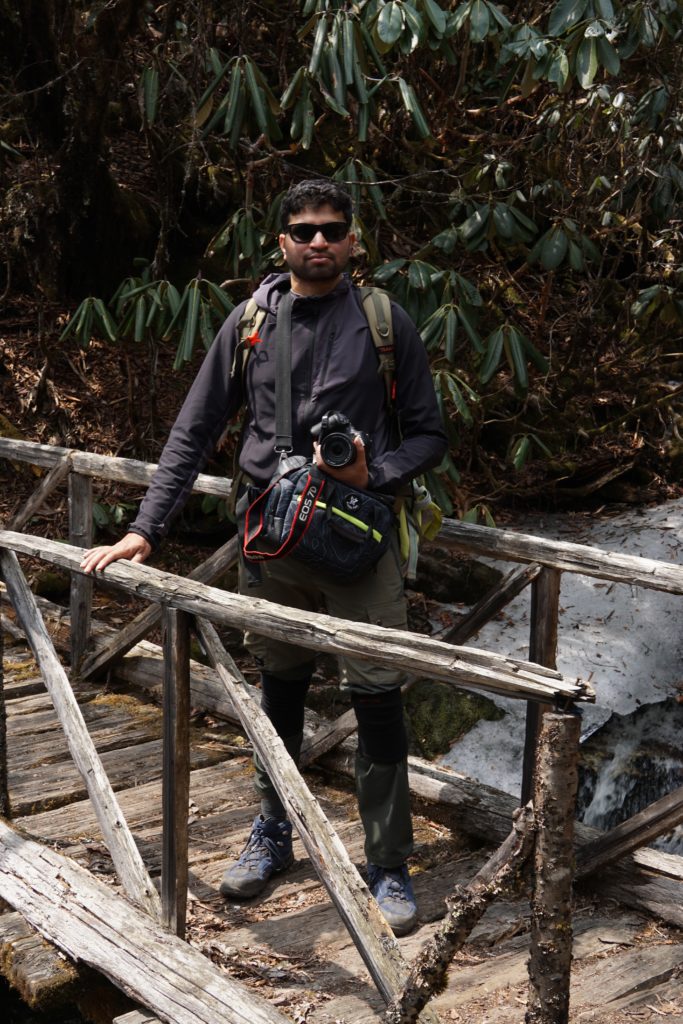 Gouresh (an IT professional from Hyderabad) posing on a wooden bridge over a stream.